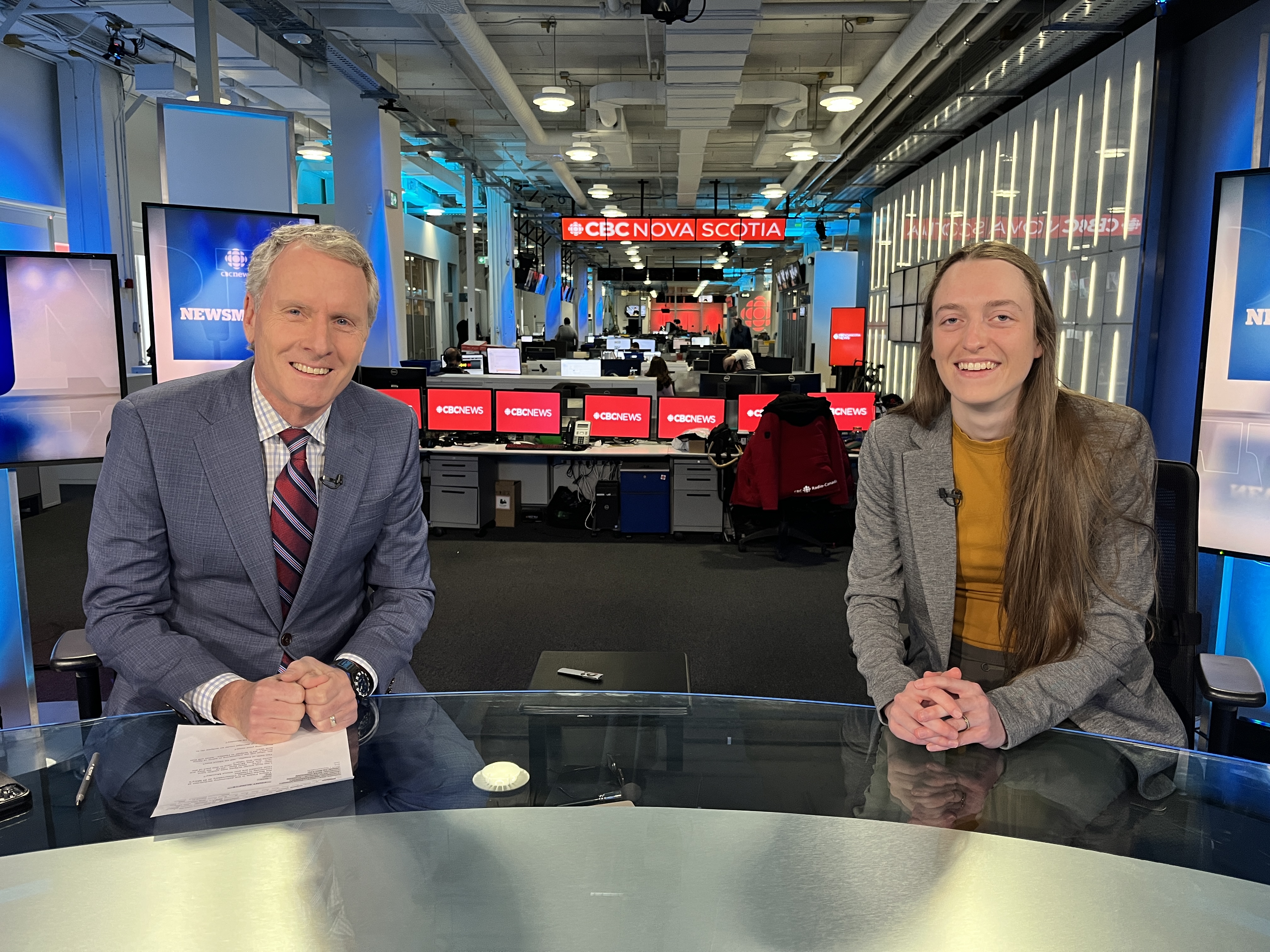 Image of Tiffany in a CBC radio studio with host Bob Murphy - we are both sitting at a desk in front of a mic, smiling towards the camera